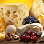 Different types of cheese over old wooden table.